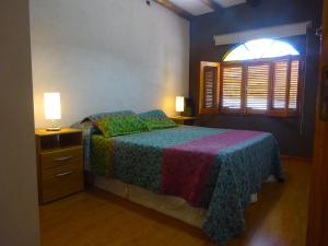 a bedroom with a bed and two lamps and a window at Apart Hotel La Bodega in San Rafael