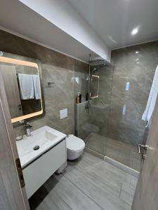 a bathroom with a shower and a toilet and a sink at MAXIM APARTMENT in Heraklio +45 photos
