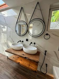 two sinks in a bathroom with two mirrors at Modern Studio with Swimming Pool in Njiro, Arusha in Arusha +33 photos