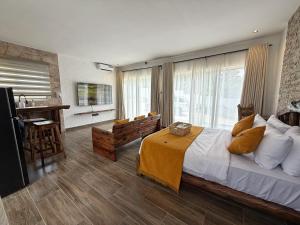 a bedroom with a large bed and a table and chairs at Modern Studio with Swimming Pool in Njiro, Arusha in Arusha