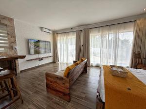 a large room with a bed and a couch andwindows at Modern Studio with Swimming Pool in Njiro, Arusha in Arusha