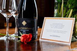 a bottle of wine and a red rose on a table at Il Castello Di San Gaudenzio in Cervesina