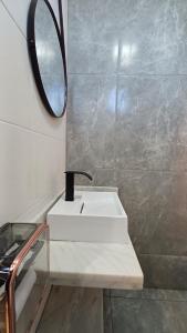 a bathroom with a white sink and a mirror at Riviera Sanary 1206 - Nova Almeida in Serra