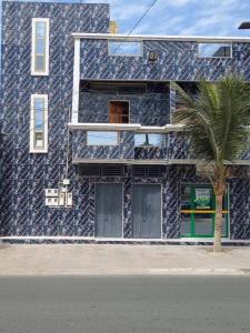 a building with a palm tree in front of it at MK Hebergement in Saint-Louis