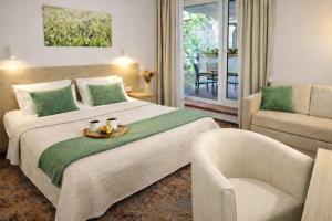 a bedroom with a large bed with a chair and a couch at HOME Apart-Hotel Vilnius in Vilnius