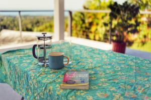 a table with a book and a coffee mug and a book at Casa Kimara in Uvita