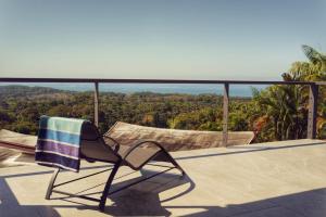 a chair sitting on a balcony with a skateboard at Casa Kimara in Uvita