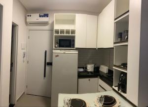 a kitchen with white cabinets and a refrigerator at Estrela Do Mar flat Beach in Porto De Galinhas