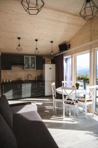 a kitchen and living room with a table and chairs at Familyhata in Dzembronya