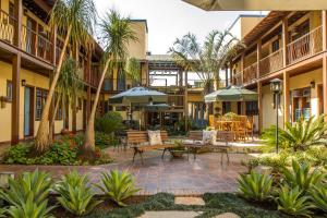 a courtyard with tables and chairs and palm trees at Pousada Rotunda in São João del Rei