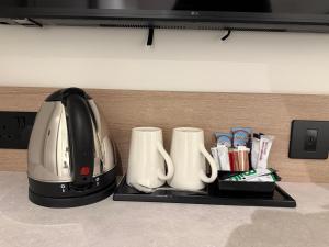 a toaster and coffee cups on a tray on a counter at Lidos Hotel in London +28 photos