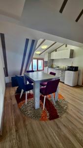 a dining room with a table and chairs on a rug at The Pine Loft by Kopaonik in Kopaonik