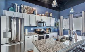 a kitchen with white cabinets and a stainless steel refrigerator at New Studio- 2 beds 7 mins to DT in Nashville