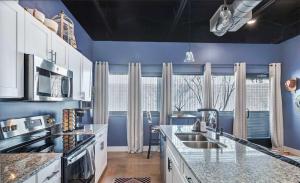 a kitchen with blue walls and a large window at New Studio- 2 beds 7 mins to DT in Nashville