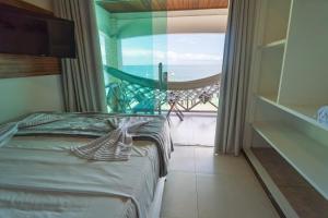a bedroom with a bed and a view of the ocean at Pousada Porto 23 in Morro de São Paulo