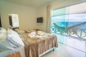 a bedroom with a bed with a view of the ocean at Pousada Porto 23 in Morro de São Paulo