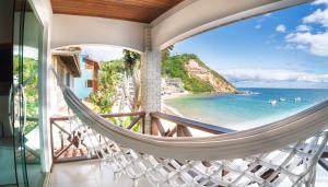 a hammock on a balcony with a view of the ocean at Pousada Porto 23 in Morro de São Paulo