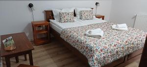 a bedroom with a bed with towels on it at Pensiunea Restaurant Vándor in Cîmpu Cetăţii