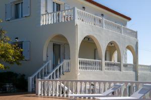 a white building with arches and a balcony at Villa Aether Methoni in Methoni +71 photos