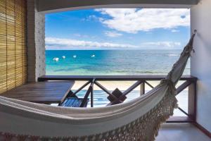 a hammock in a room with a view of the ocean at Pousada Porto 23 in Morro de São Paulo +16 photos
