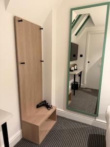 a mirror in a room with a pair of shoes at Lidos Hotel in London
