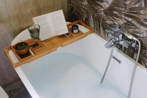 a bathtub with a book and a candle and a glass at Villa Natura in Bosanska Gradiška +51 photos