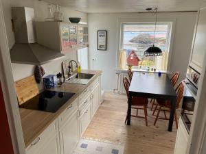 a kitchen with a table and a dining room at Ocean view from front parquet in Oyndarfjørður +14 photos