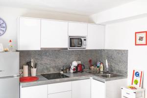 a kitchen with white cabinets and a microwave at Apartment Sweet Studio in Punat +8 photos