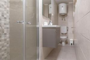 a bathroom with a shower with a toilet and a sink at Apartment Sweet Studio in Punat