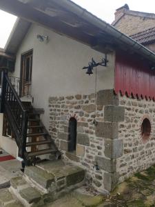 a stone building with a staircase on the side of it at Charme en pleine nature in Thauron