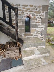 a stone building with a window and a staircase at Charme en pleine nature in Thauron +3 photos