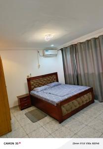 ein Schlafzimmer mit einem Bett in einem Zimmer in der Unterkunft Nancy Real Estate in Limbe