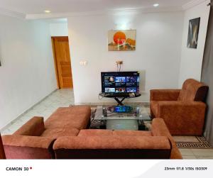 ein Wohnzimmer mit Sofa und Fernseher in der Unterkunft Nancy Real Estate in Limbe