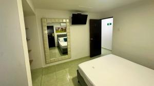 a small room with a bed and a mirror at Hotel Casa Paraiso in Barranquilla +22 photos