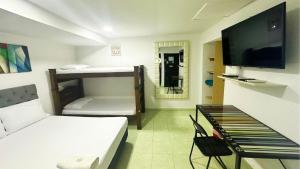 a room with two bunk beds and a tv at Hotel Casa Paraiso in Barranquilla