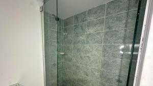 a shower with a glass door in a bathroom at Hotel Casa Paraiso in Barranquilla
