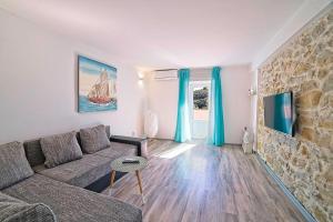 a living room with a couch and a stone wall at House Dawn in Rab