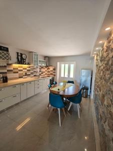 a kitchen with a wooden table and blue chairs at House Dawn in Rab