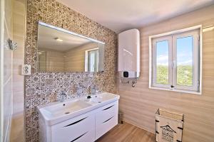 a bathroom with a sink and a mirror at House Dawn in Rab +39 photos