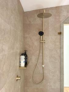 a shower with a shower head in a bathroom at Bronte Cottage in Lawson