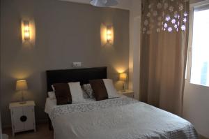 a bedroom with a bed and two lamps and a window at Hostal Don Peque in Nerja