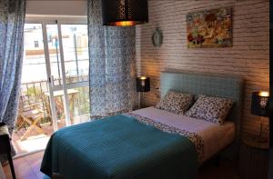 a bedroom with a bed and a large window at Hostal Don Peque in Nerja