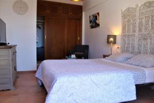 a bedroom with a large bed with a white bedspread at Hostal Don Peque in Nerja +129 photos