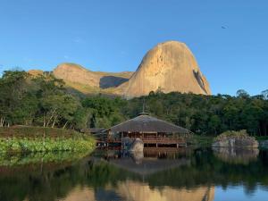 a hut on the water with a mountain in the background at Riviera Sanary 1206 - Nova Almeida in Serra