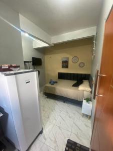 a bedroom with a bed and a refrigerator at Espaço completo no Umarizal centro de Belém in Belém