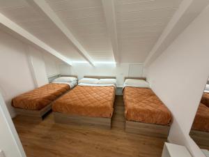 a attic bedroom with three beds in it at B&B Sant'Angelo Sala Consilina in Sala Consilina