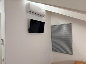 a room with a tv on a white wall at B&B Sant'Angelo Sala Consilina in Sala Consilina