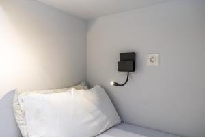 a white room with a bed with a pillow and a lamp at BaruHaus GRUPOS Alea ALOJAMIENTO COMPLETO in León