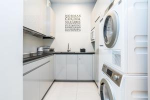 a white kitchen with a washer and dryer at BaruHaus GRUPOS Alea ALOJAMIENTO COMPLETO in León +8 photos