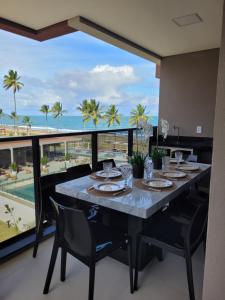 a dining room with a table and a view of the ocean at Cais Eco Residência in Ipojuca